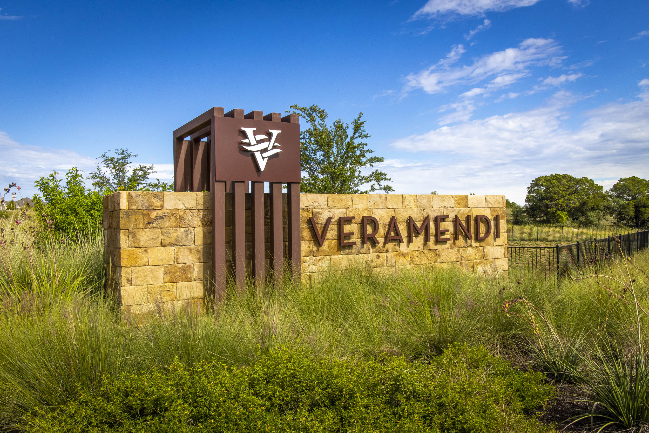 Stone and rusted metal entryway sign at Veramendi MPC